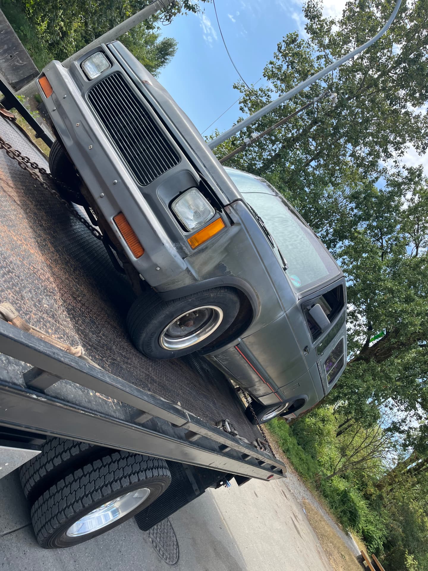 A classic convertible loaded on Jay's white flatbed truck